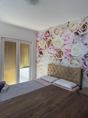 a bedroom with a mural of roses on the wall at Jorgovan in Bečići