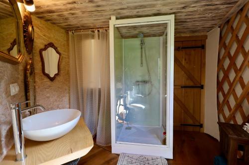 a bathroom with a white sink and a shower at Les Yourtes de La Valette in Floreffe
