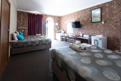a hotel room with two beds and a kitchen at The Argent Motel in Broken Hill