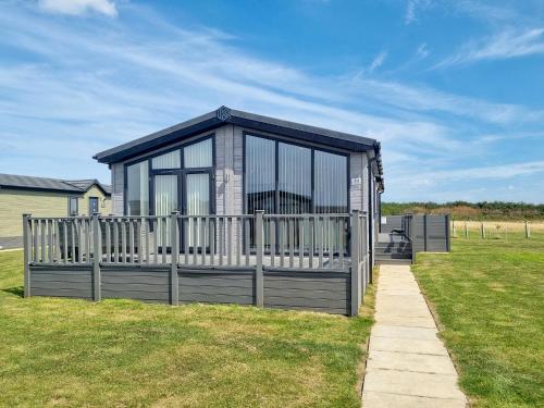 a building with a fence in the grass at Cherry Blossom 39 - Uk50708 in Garton