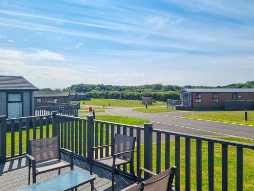 a deck with two chairs and a table and a road at Cherry Blossom 39 - Uk50708 in Garton