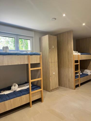 a room with three bunk beds and a window at Albergue Hostel Barosa in Barro