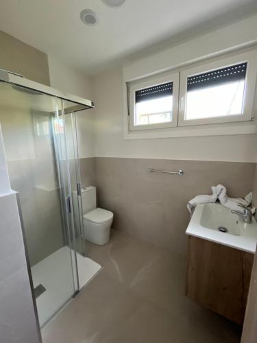 a bathroom with a shower and a sink and a toilet at Albergue Hostel Barosa in Barro