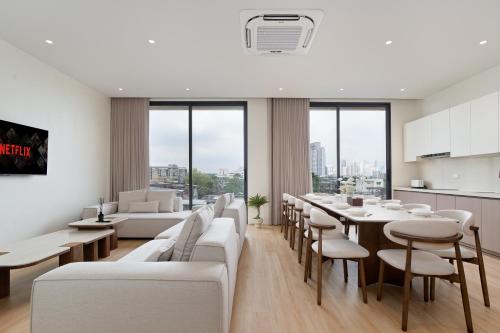 a living room with white furniture and a table and chairs at Haus 42 in Bangkok