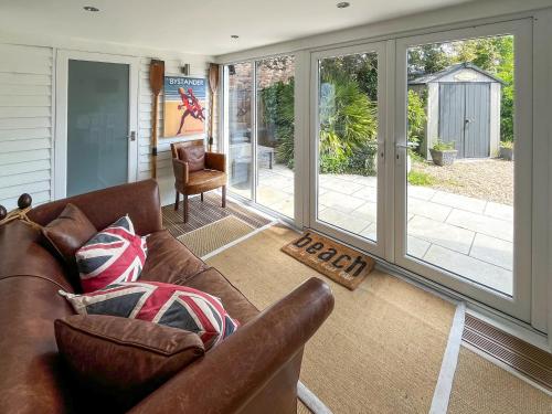 a living room with a leather couch and sliding glass doors at The Admirals in Sutton on Sea