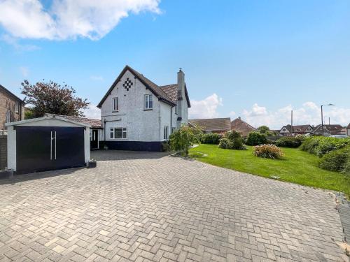 a large white house with a driveway at The Admirals in Sutton on Sea