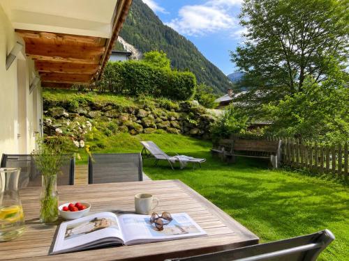 a wooden table with an open book on top of a yard at Ferienlodge Alpenkönigin Vacation in Stubai Valley in Neustift im Stubaital