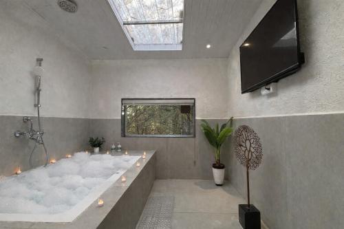 a large bath tub in a bathroom with a skylight at Cloud 9 Hills Resort in Lonavala