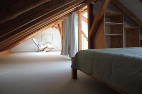 a bedroom with a bed and a chair next to a window at Erholung im Grünen in Weissach