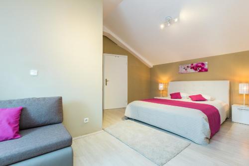 ein Schlafzimmer mit einem Bett und einem Sofa in der Unterkunft Villa Elisabeth in Biograd na Moru