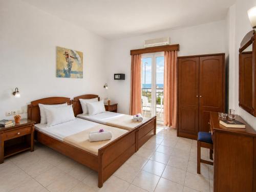 a bedroom with a bed and a desk and a window at Astir Studios in Stalís