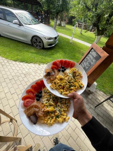 a person holding a plate of food on a table at Cabana Carolina in Laz