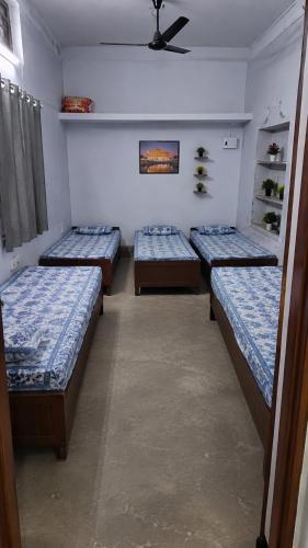 a room with four beds in it with a fan at The Heritage Eco Stay in Bikaner