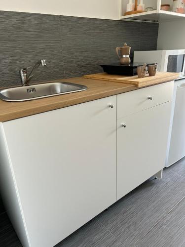 a kitchen with white cabinets and a sink at di fronte al museo in Gela