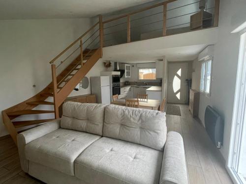 a living room with a couch and a staircase at Sable d or wissant in Wissant
