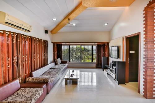 a living room with couches and a tv at Cloud 9 Hills Resort in Lonavala