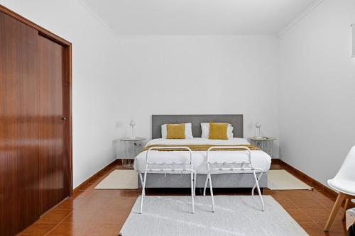 a bedroom with a white bed with yellow pillows at Casa MiRaMar in Mosteiros
