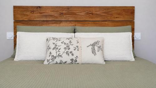a bed with two pillows and a headboard at Logement indépendant dans villa direct plage Lac Leman Evian in Publier
