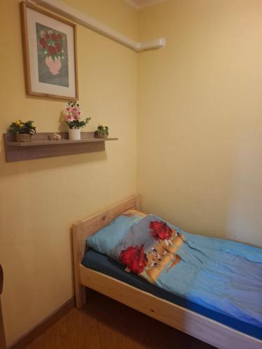 a bedroom with a bed with flowers on it at Juci Home Apartman in Vonyarcvashegy