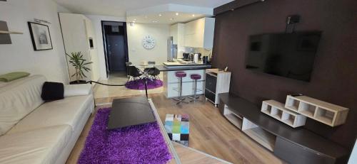 a living room with a white couch and a tv at Apartman Jo Ma MA in Solin