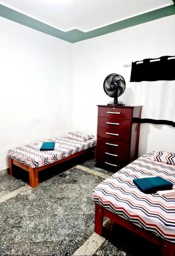 a room with two beds and a dresser in it at Casa Verde in Limeira