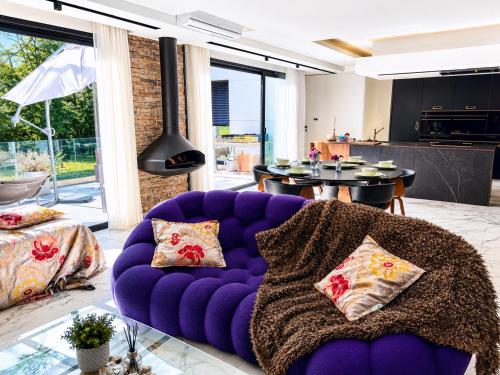 a purple couch with pillows in a living room at Contemporary villa between Paris and Disneyland in Champs-sur-Marne