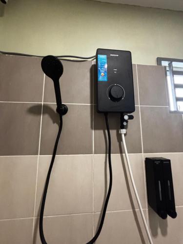 a phone is plugged into a wall at Amara Homestay Gurun in Kampong Bongkok