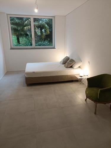 a bedroom with a bed and a chair and a window at Paradise 31 in Paradiso