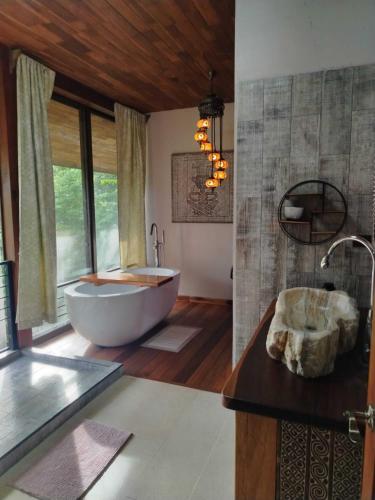 a large bathroom with a tub and a large window at Stays at Corcovado Nature Villas in Puerto Jiménez