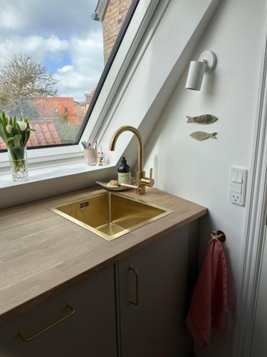 a kitchen with a sink and a window at Old Town Loft Middelfart in Middelfart