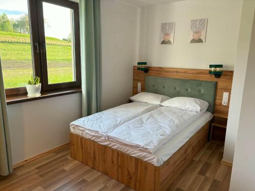 a bedroom with a bed in a room with a window at Biała Ostoja 517-539-965 in Berezka