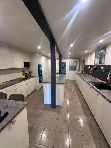 a large kitchen with white cabinets and a blue pole at Walteri guest house in Tetele