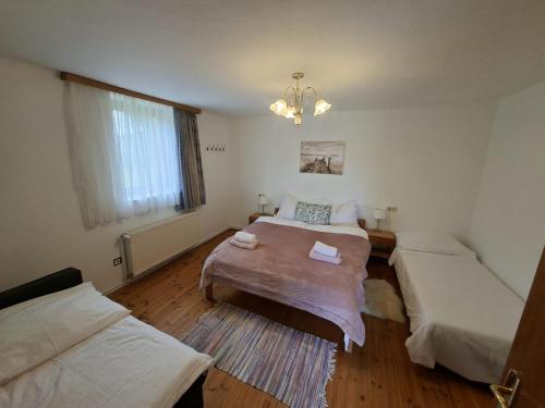 a bedroom with two beds and a chandelier at Chalet an der Sonne nahe Klopeiner See und Petzen Bergbahn in Sankt Stefan