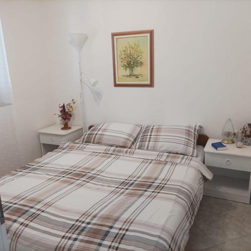 a bed with a striped comforter in a bedroom at B&B Sveti Petar in Sveti Petar