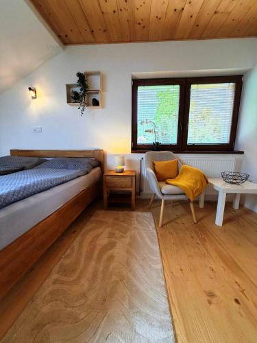 a bedroom with a bed and a chair and windows at Apartmán Kunratice 2 in Kunratice
