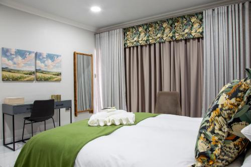 a hotel room with a bed and a desk at Guest at 58 in Lydenburg