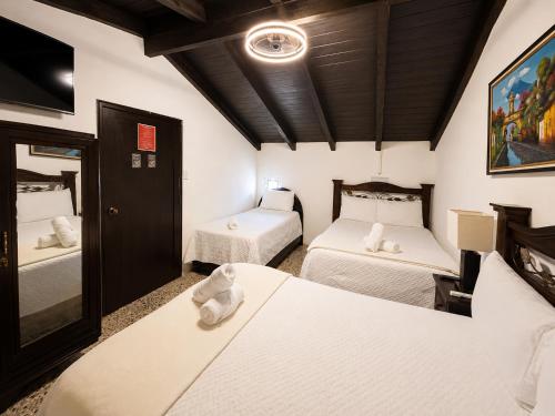 a room with two beds in a room at Casa de la Torre in Antigua Guatemala