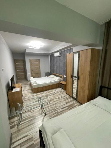 a hotel room with two beds and a roomthritisthritisthritisthritisthritisthritisthritis at Hayq in Yerevan