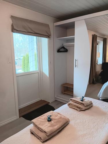 a bedroom with two towels on a bed with a window at Studio Leilighet in Moss