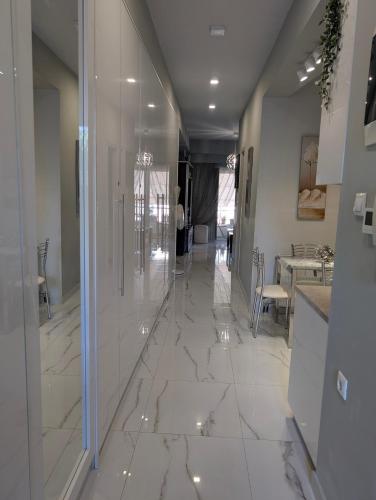 a hallway with white marble flooring in a house at EV Apartment with free parking place in Volos