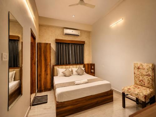 a bedroom with a bed and a chair in it at Hotel Banyan Courtyard Guwahati in Guwahati