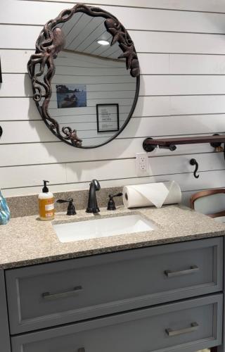 a bathroom vanity with a sink and a mirror at Camp Squid Off The Grid in Benzonia