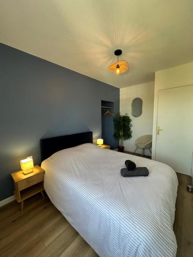 a bedroom with a white bed and a ceiling at Le Nid de la Mayenne in Mayenne