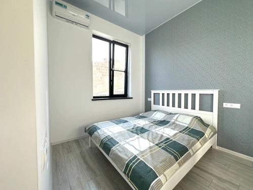 ein weißes Schlafzimmer mit einem Bett und einem Fenster in der Unterkunft White Location in Dzoraghpʼyur