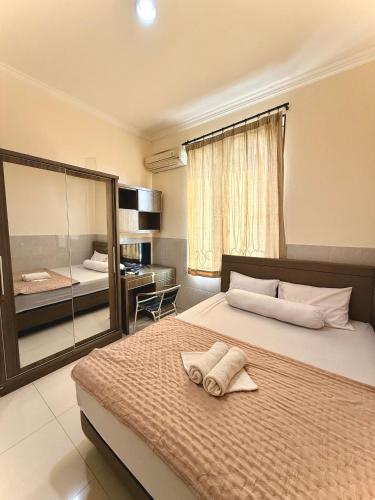 a bedroom with a large bed with a mirror at Emerald Inn Karawaci in Dungus