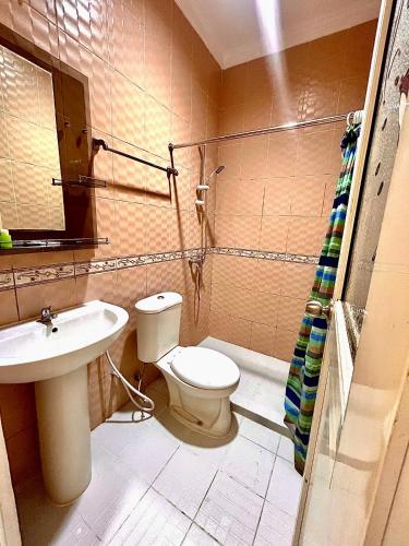a bathroom with a toilet and a sink at Emerald Inn Karawaci in Dungus