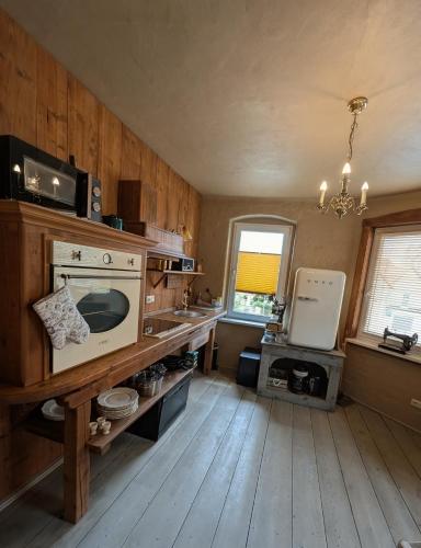 a kitchen with wooden floors and a stove top oven at Ferienwohnung Viktoria - Vintage Apartment in Bad Klosterlausnitz