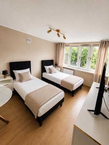 ein Schlafzimmer mit zwei Betten und einem Flachbildfernseher in der Unterkunft Golden Studio in Płock