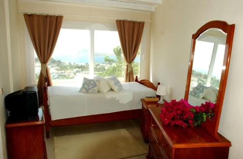 a bedroom with a bed and a mirror and a window at Oryx Homes & Villas in Bodrum City