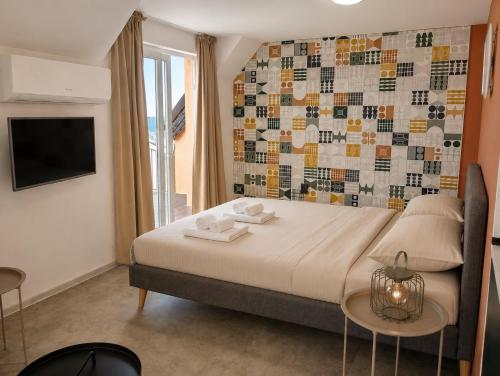 a bedroom with a large bed with a mosaic wall at Apartments Provence in Sozopol